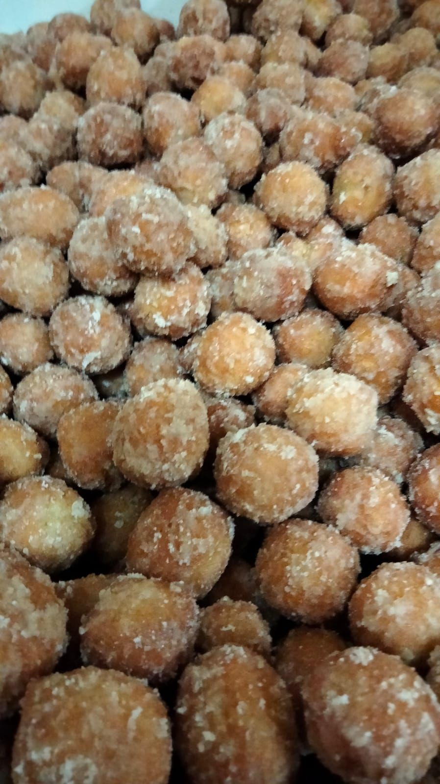 Una pila di ciambelle ricoperte di zucchero su un tavolo.