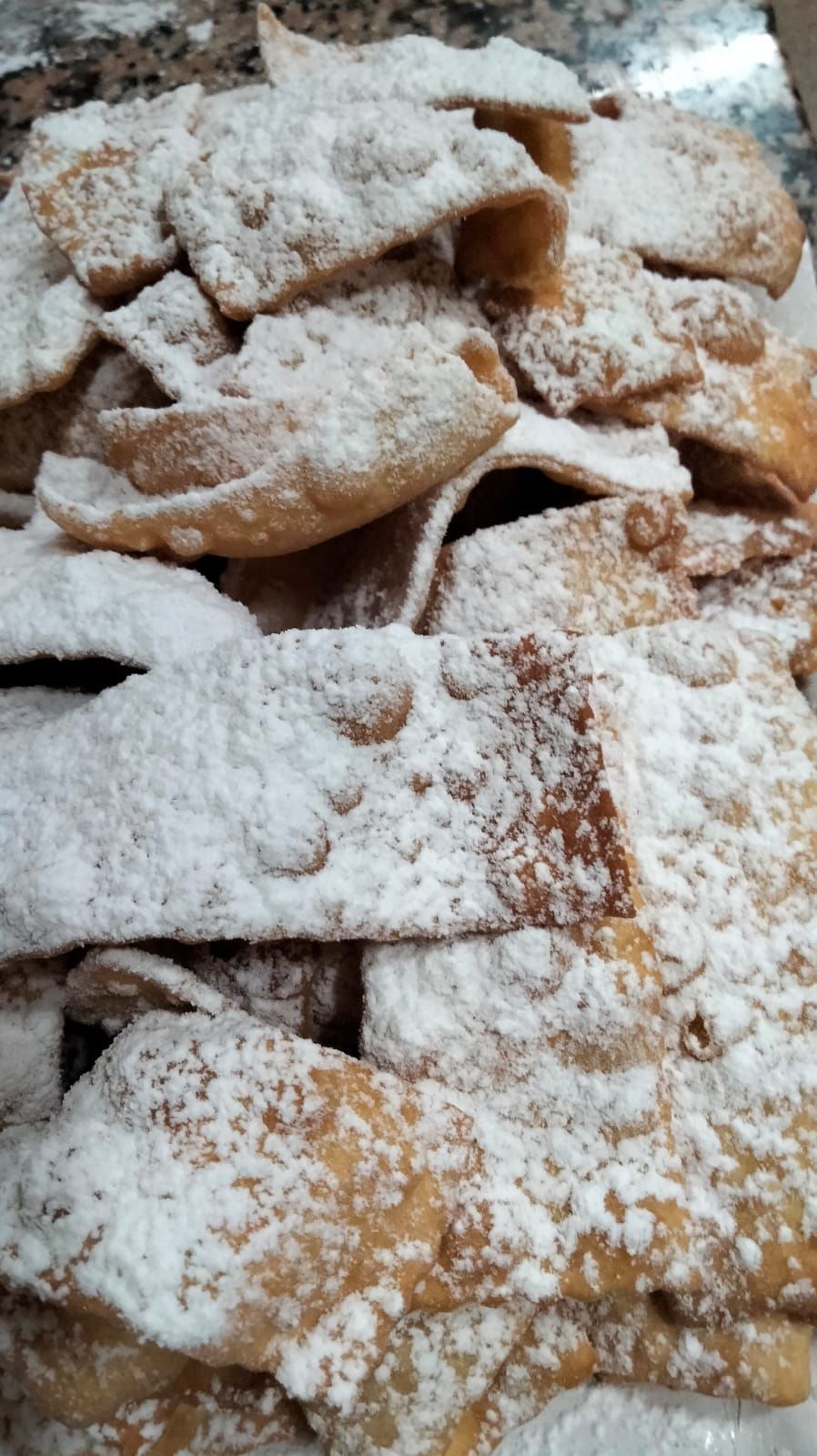 Una pila di cibo ricoperta di zucchero a velo su un tavolo.