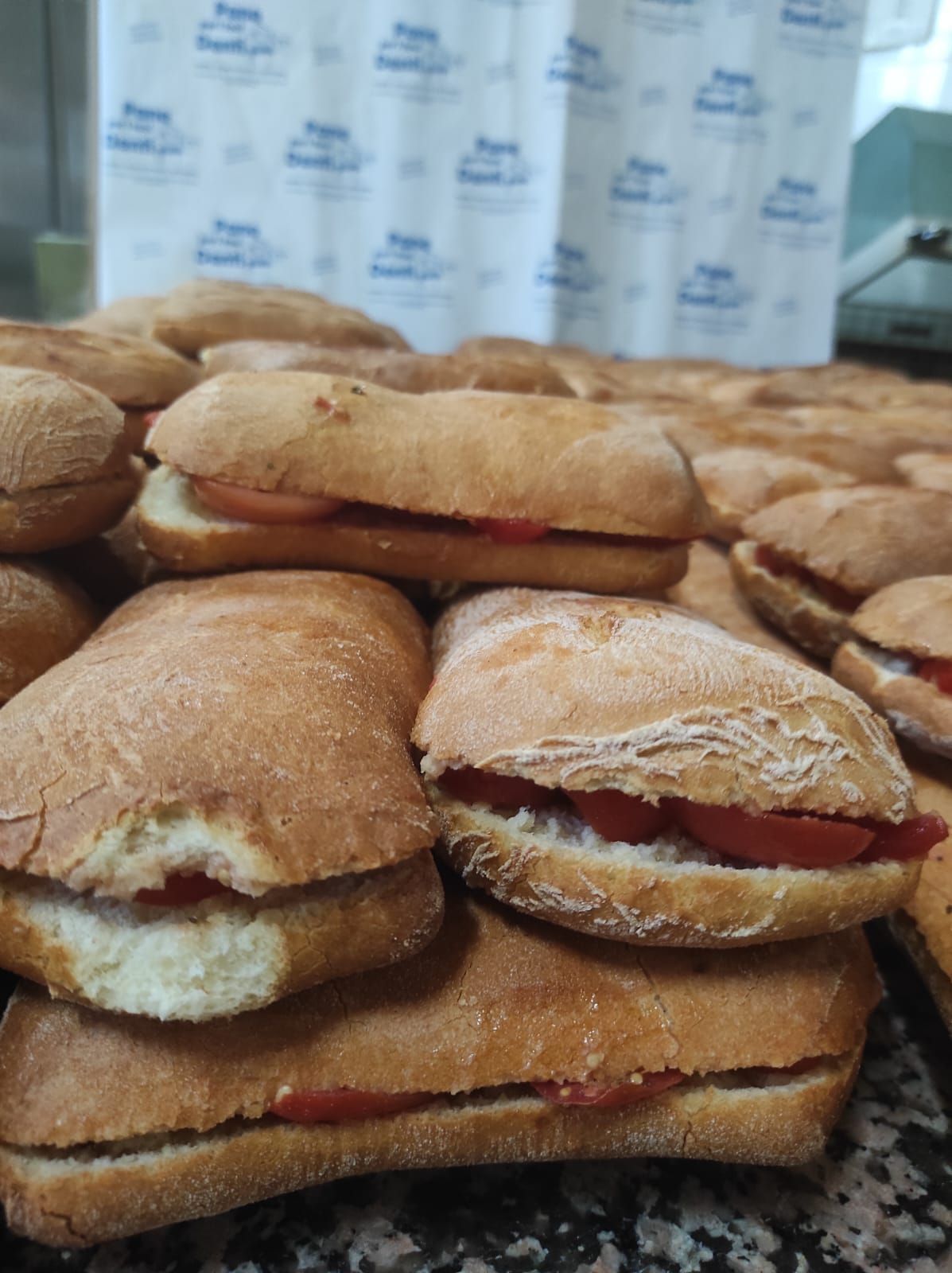 Un mucchio di panini sono impilati uno sopra l'altro su un tavolo.