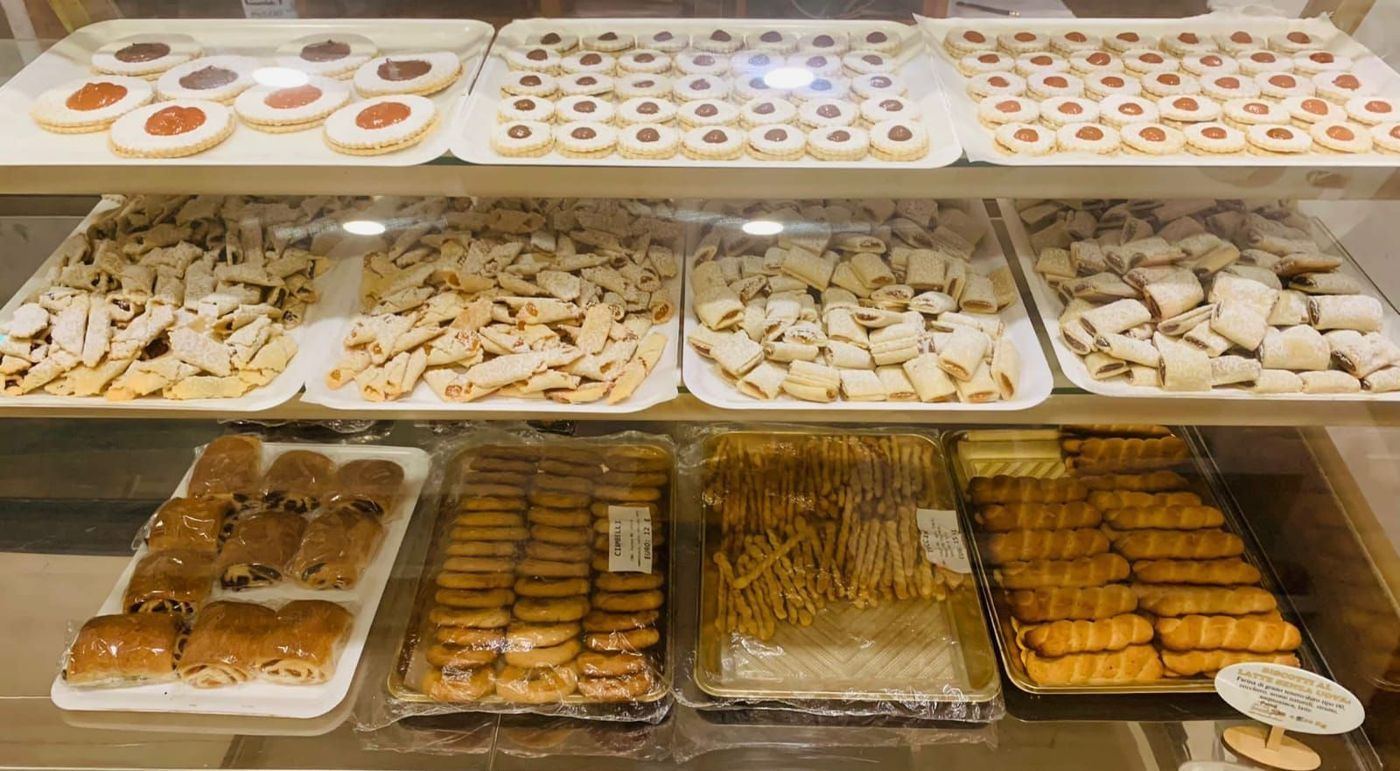 Una vetrina piena di tantissimi tipi diversi di pasticcini.