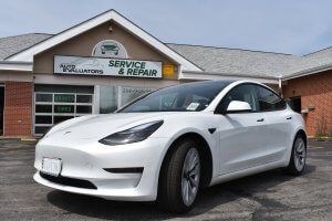 A White Electric Vehicle is Parked in Front of Auto Evaluators in St. Louis, MO