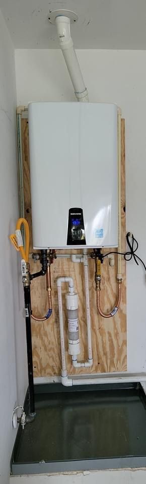 A white boiler is sitting on top of a wooden wall in a room.