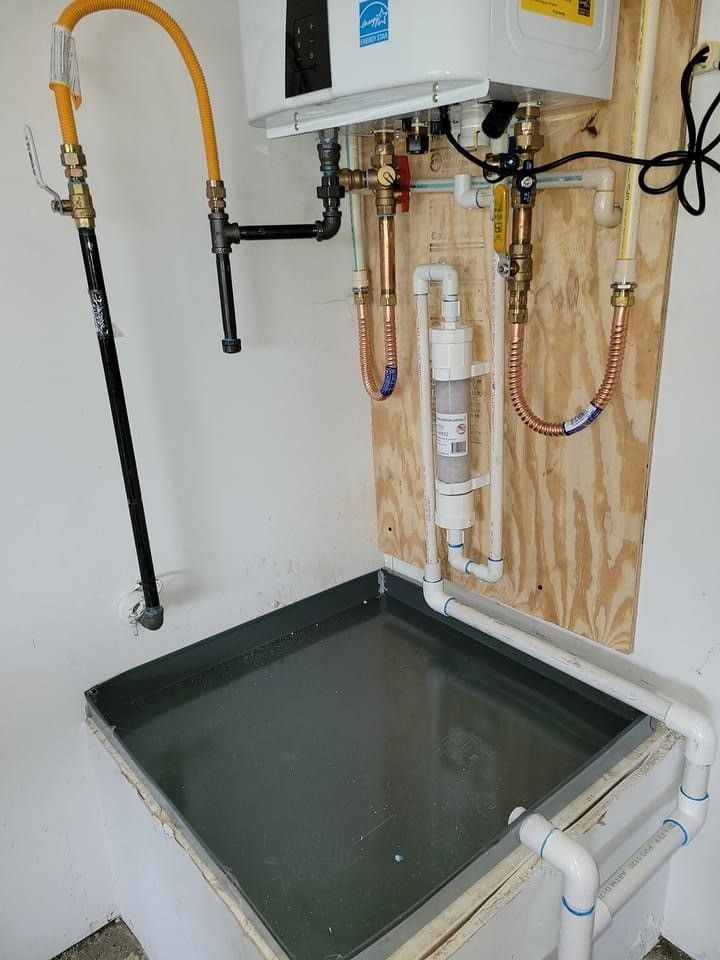 A room with a water heater and a tray of water.