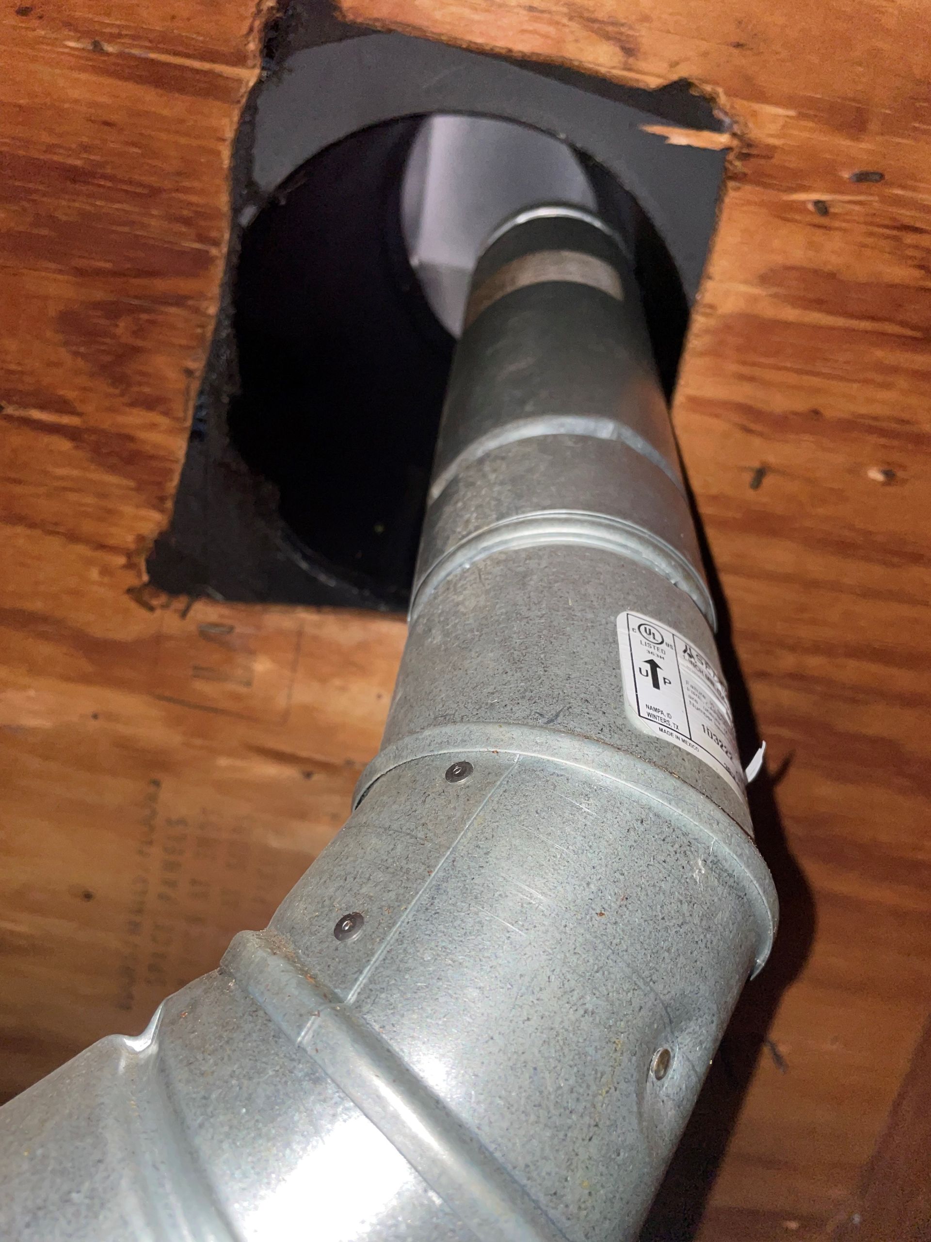 A metal pipe is coming out of a hole in the ceiling