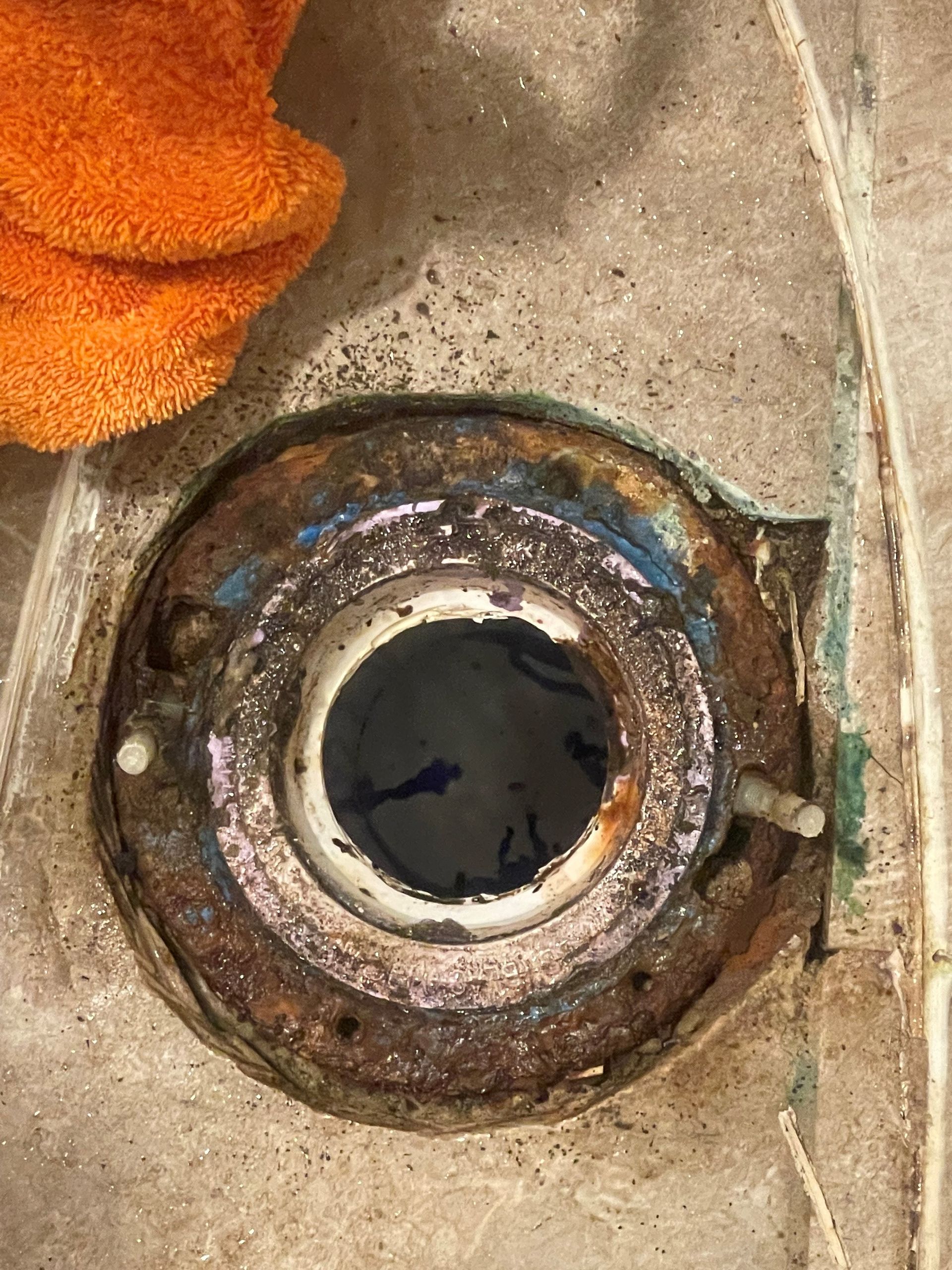 A close up of a rusty metal object with a hole in the middle.