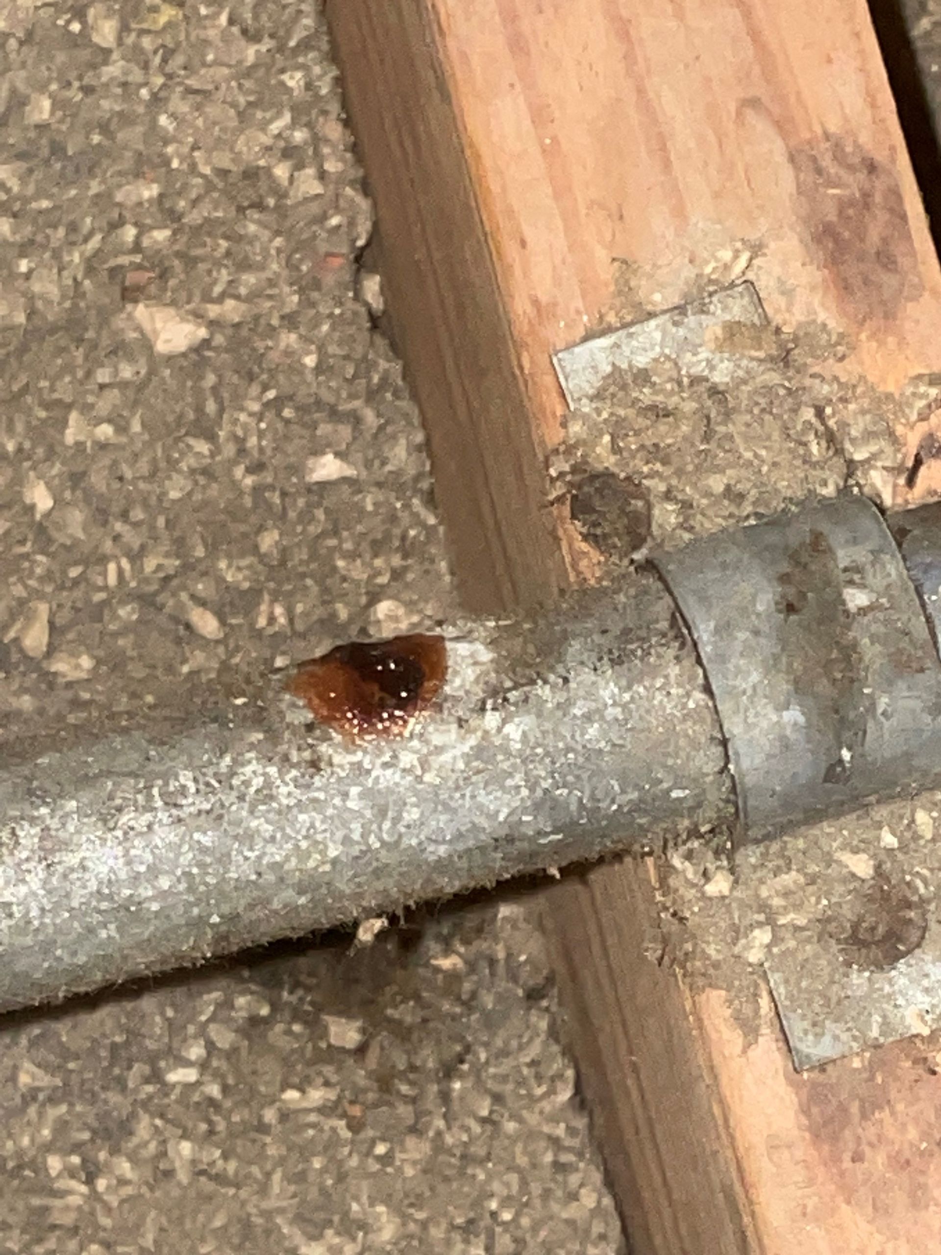 A close up of a metal pipe with a hole in it.