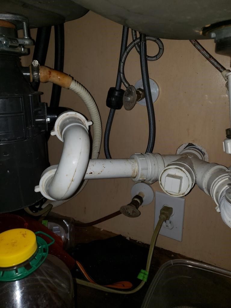 A sink with a garbage disposal underneath it.