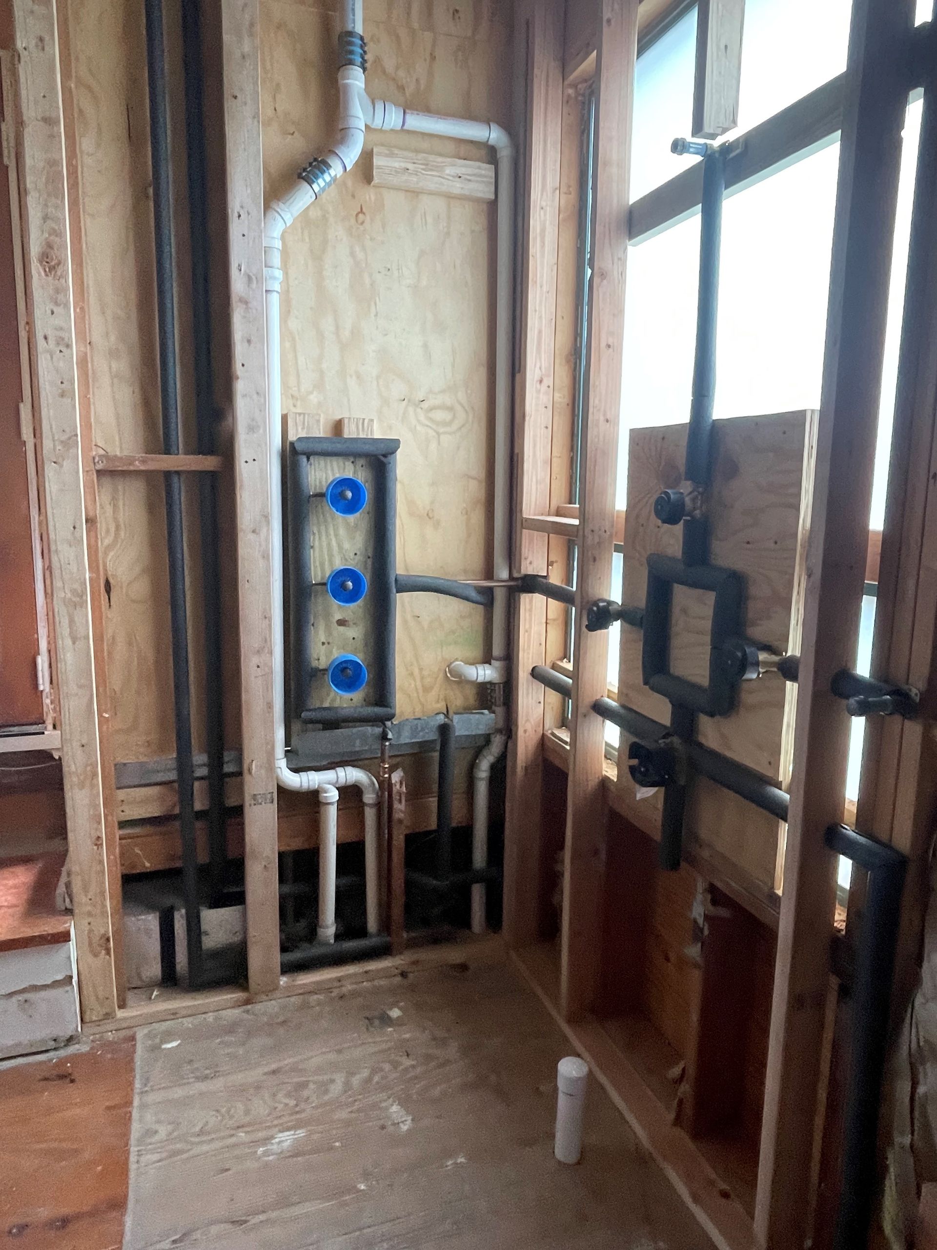 A bathroom under construction with a lot of pipes