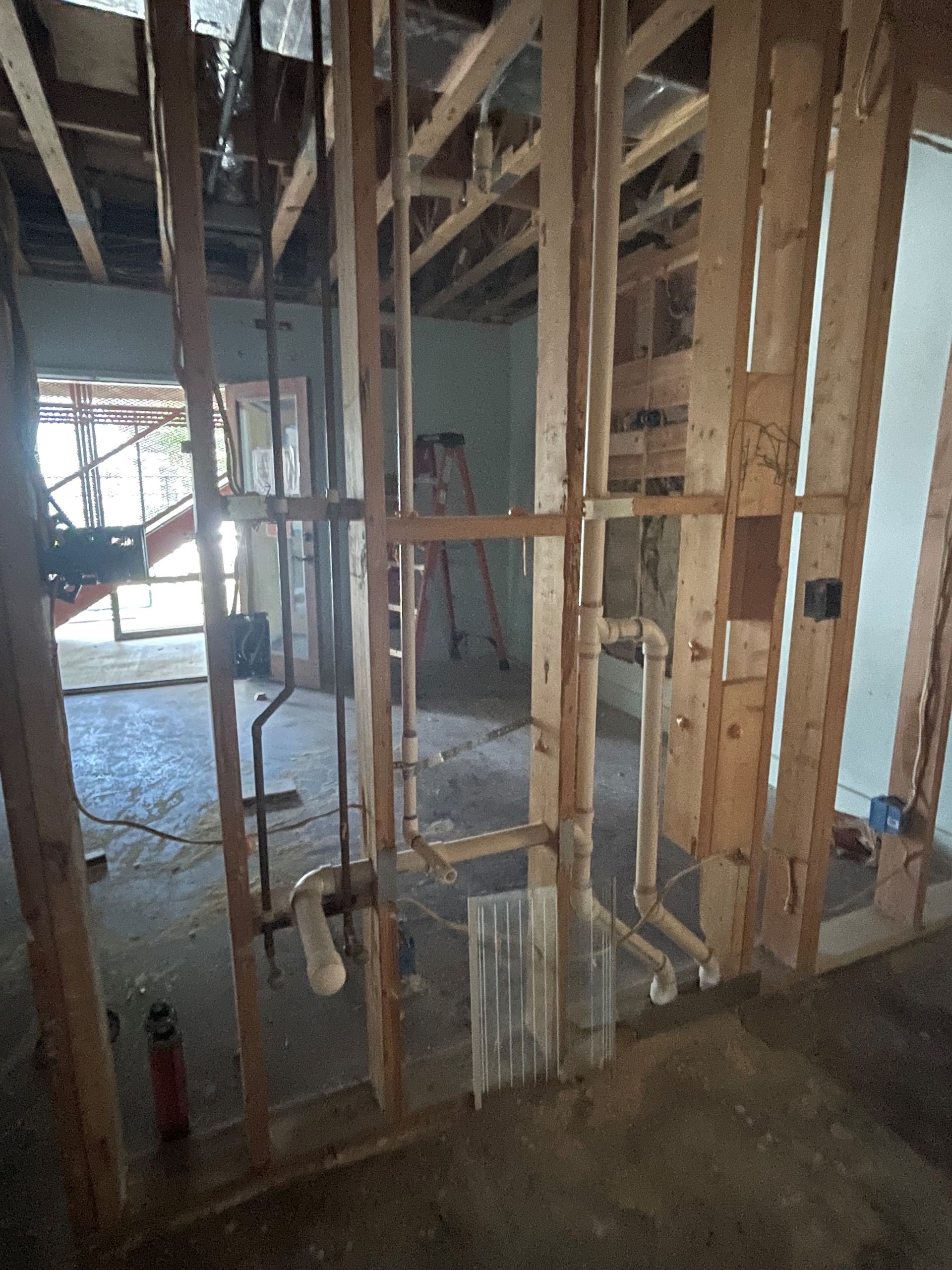 A room with a lot of wooden beams and pipes in it