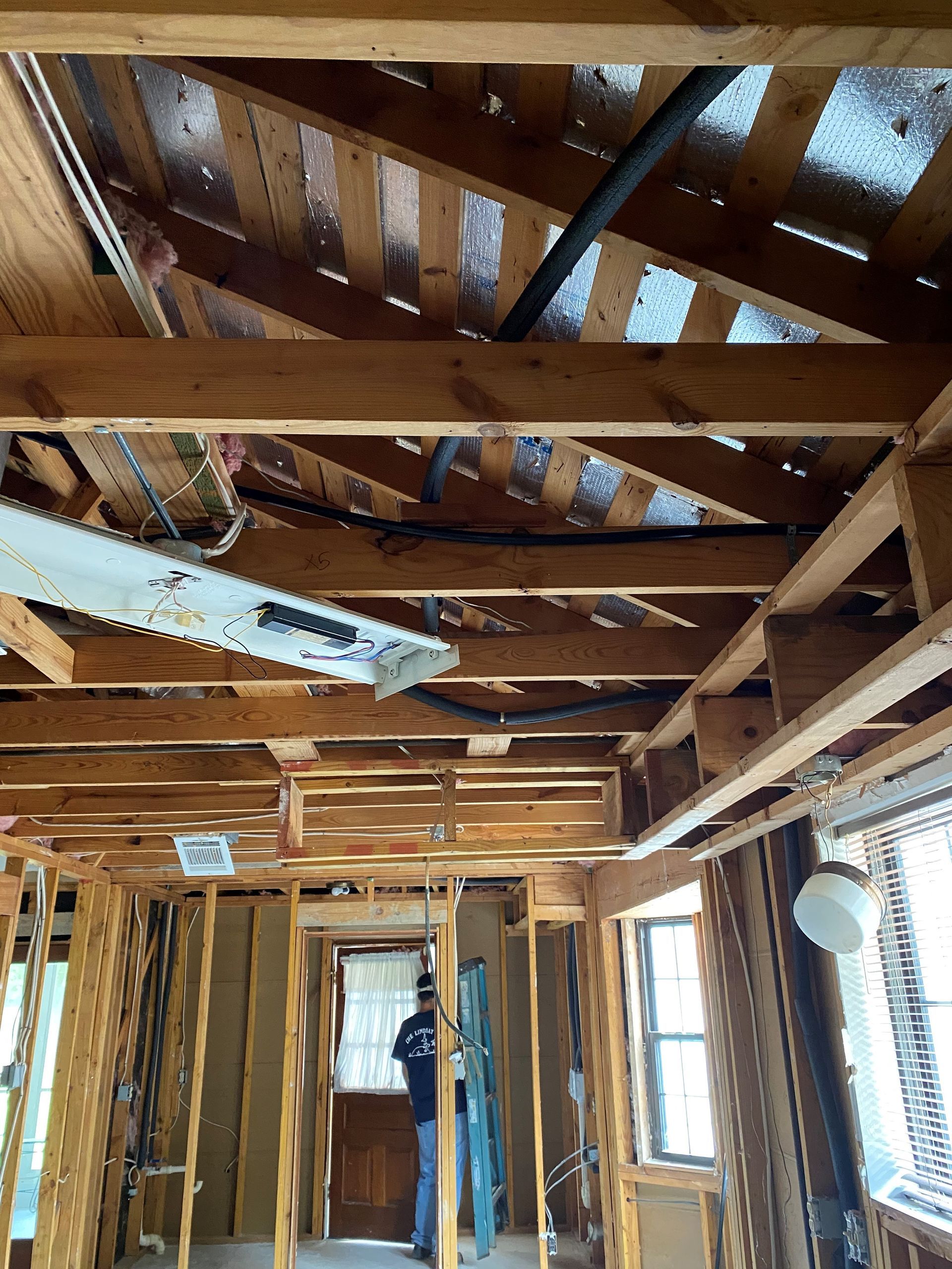 A man is standing in the middle of a house under construction.