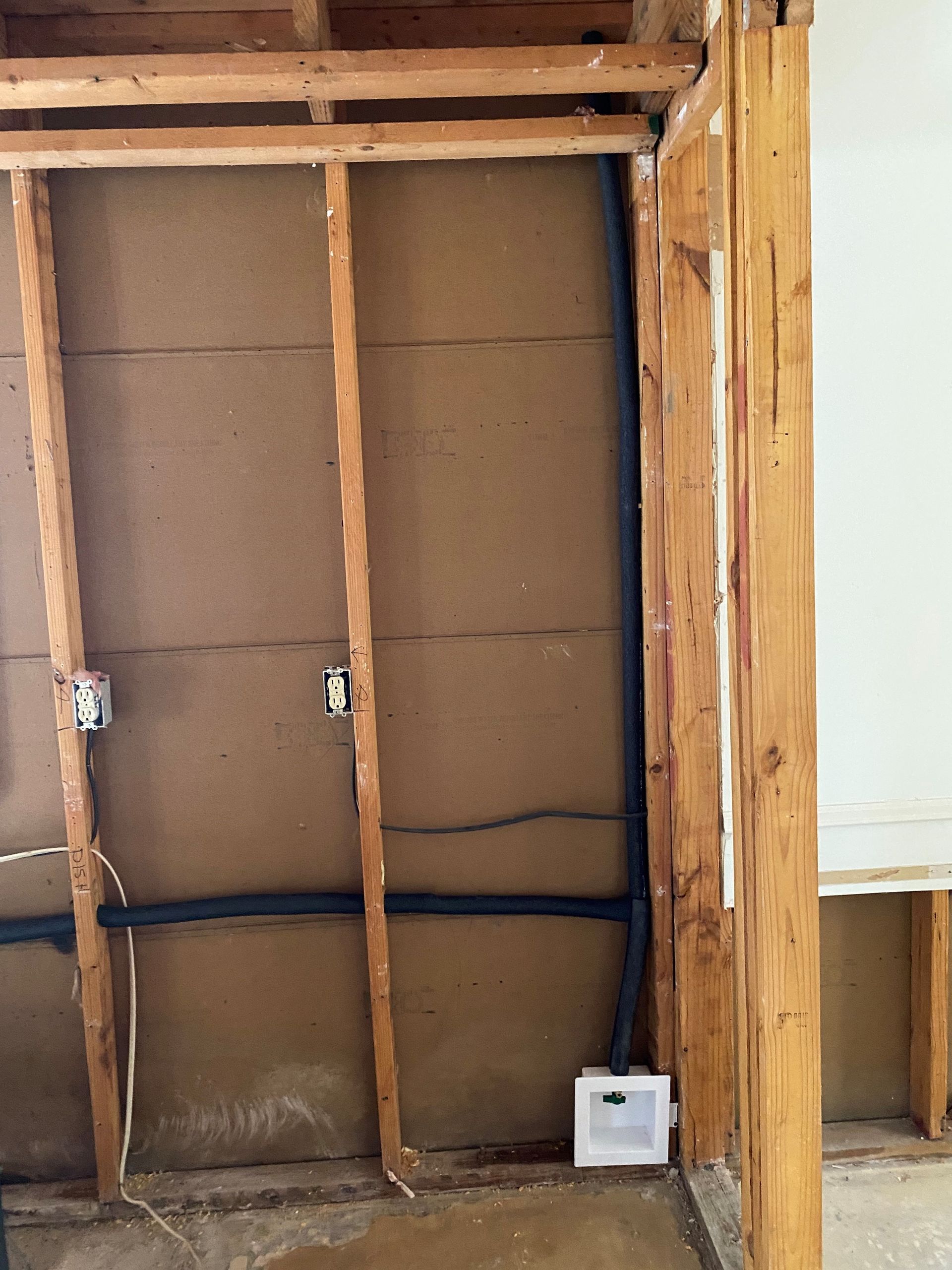 A wooden wall with electrical wires coming out of it