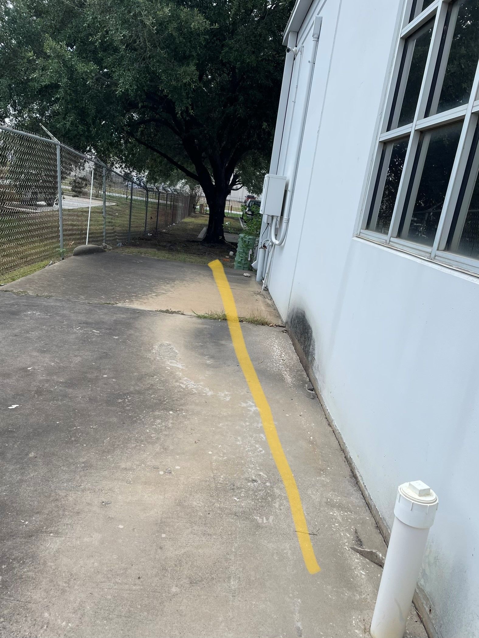 A yellow line is painted on the side of a building.