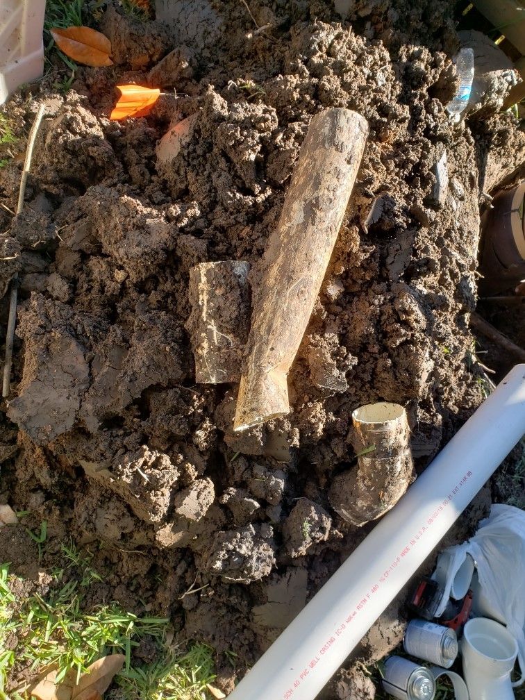 A pile of dirt with a piece of wood in it.