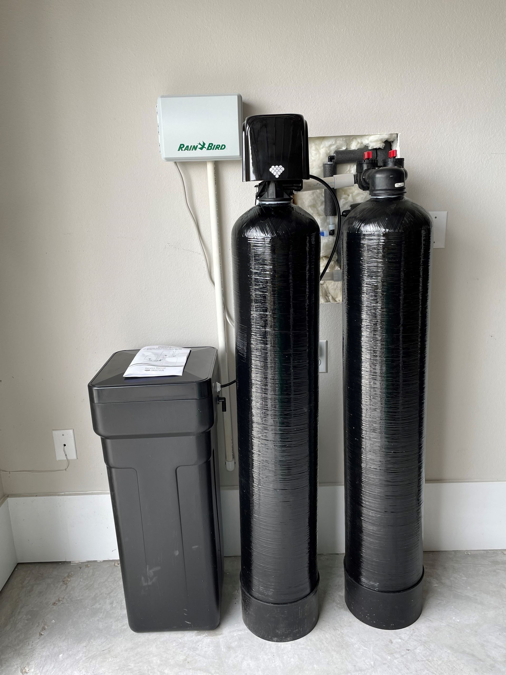 Two black cylinders are sitting next to each other in a room.