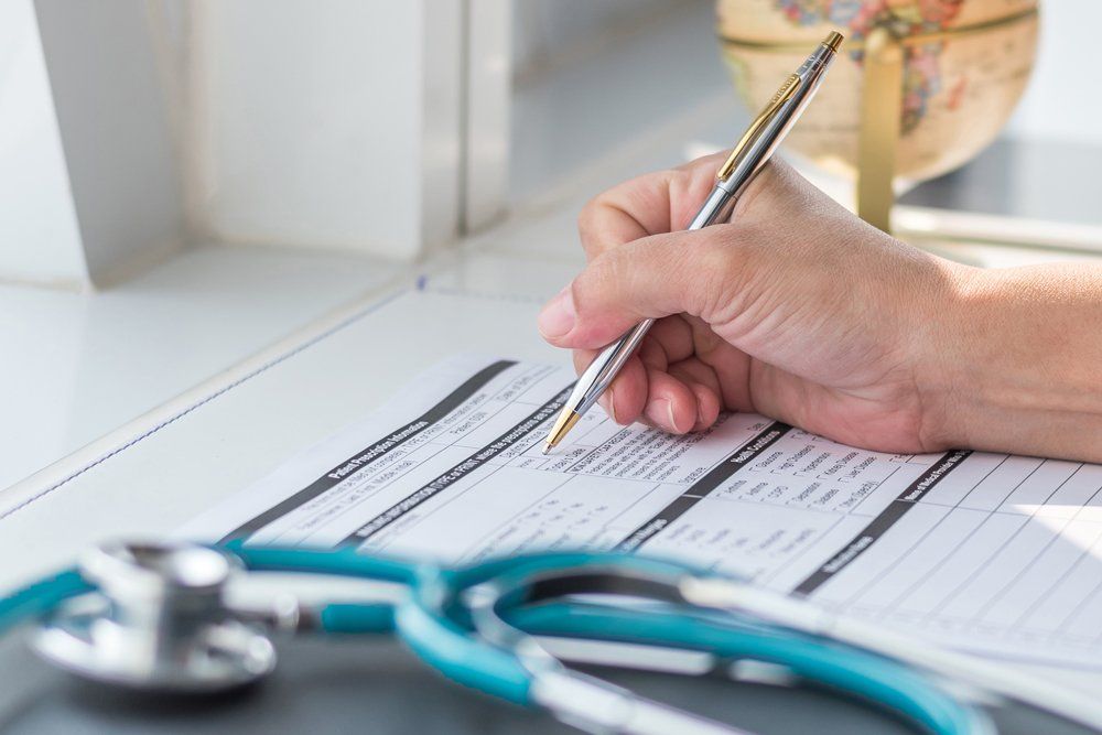 Doctor writing on medical health care record