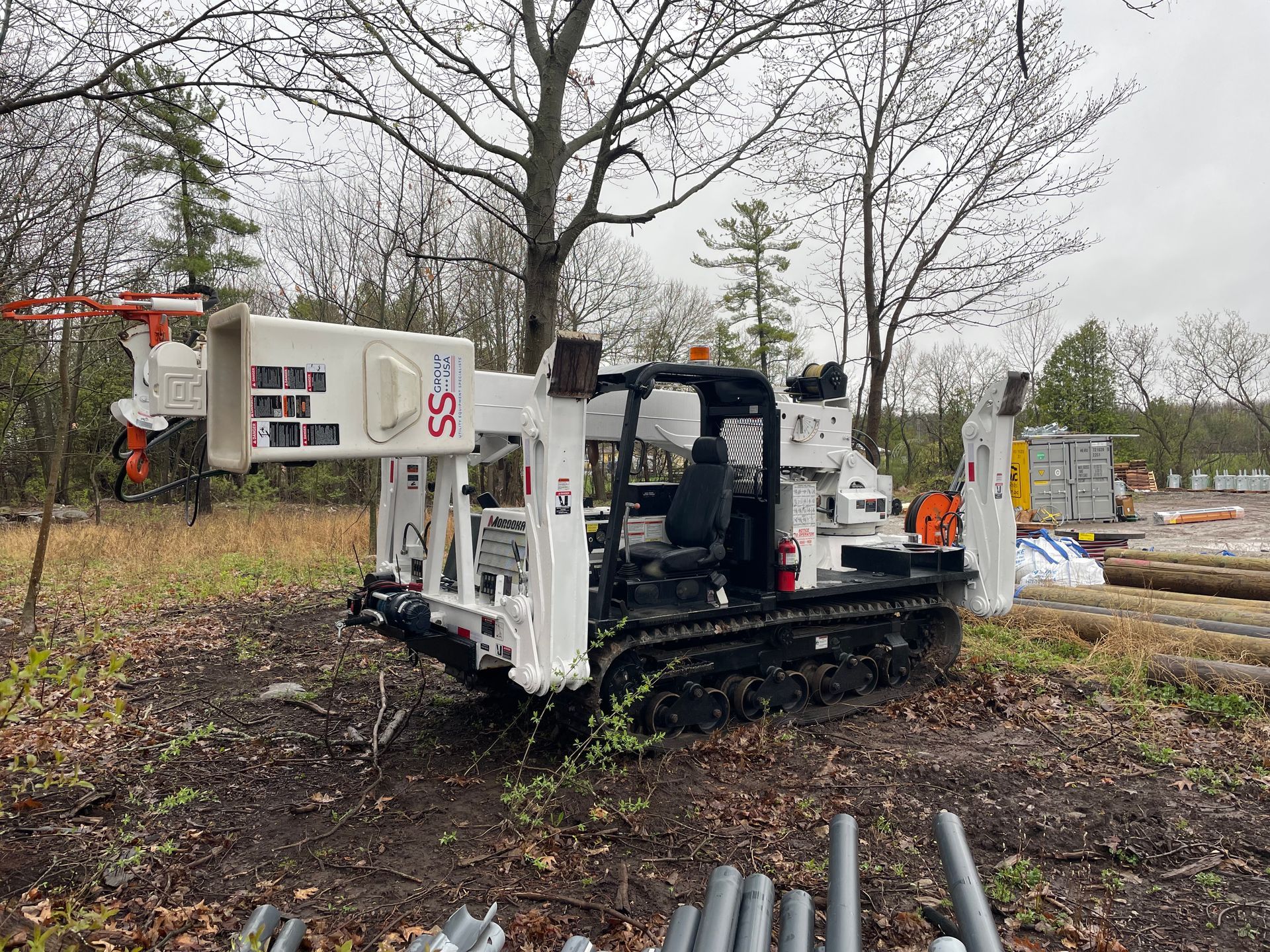 A white and black construction vehicle is parked in a field.