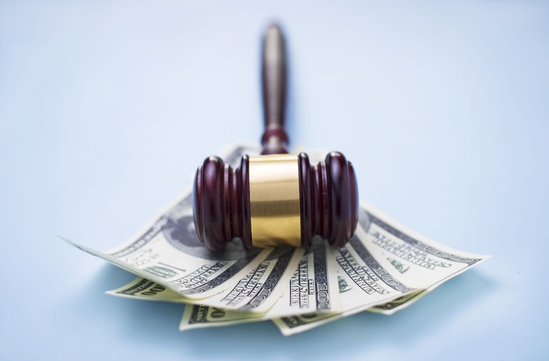 A judge 's gavel is sitting on top of a pile of money.