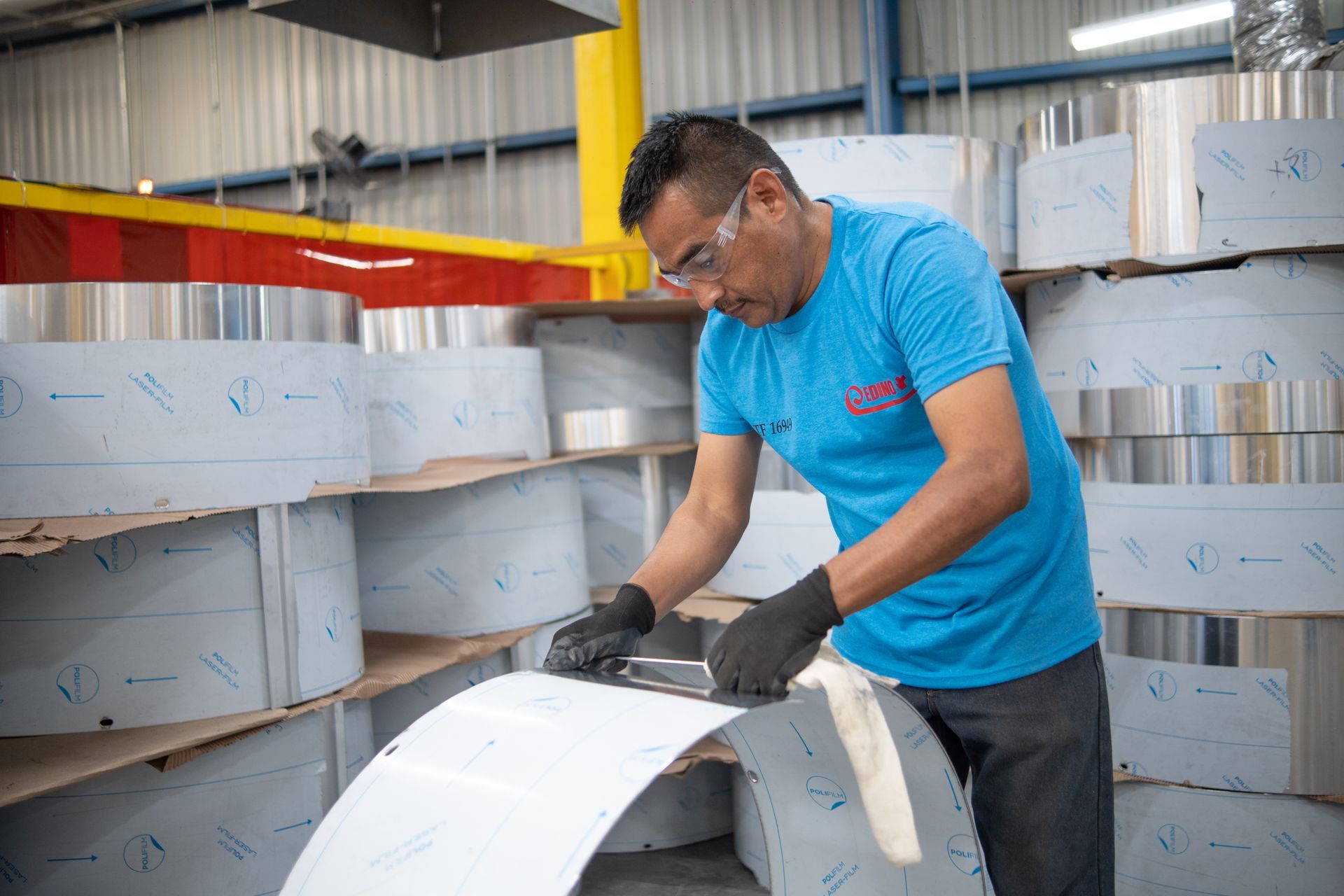 un hombre está trabajando en una pieza de metal en una fábrica.