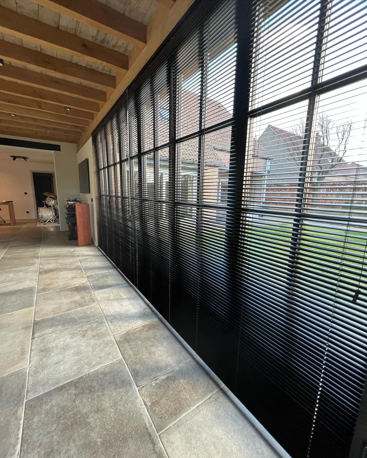 Een lange gang met veel ramen en jaloezieën.