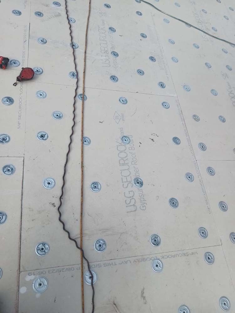 A high-angle view of a floor covered in USG Securock cement board panels, secured with numerous evenly spaced washers.