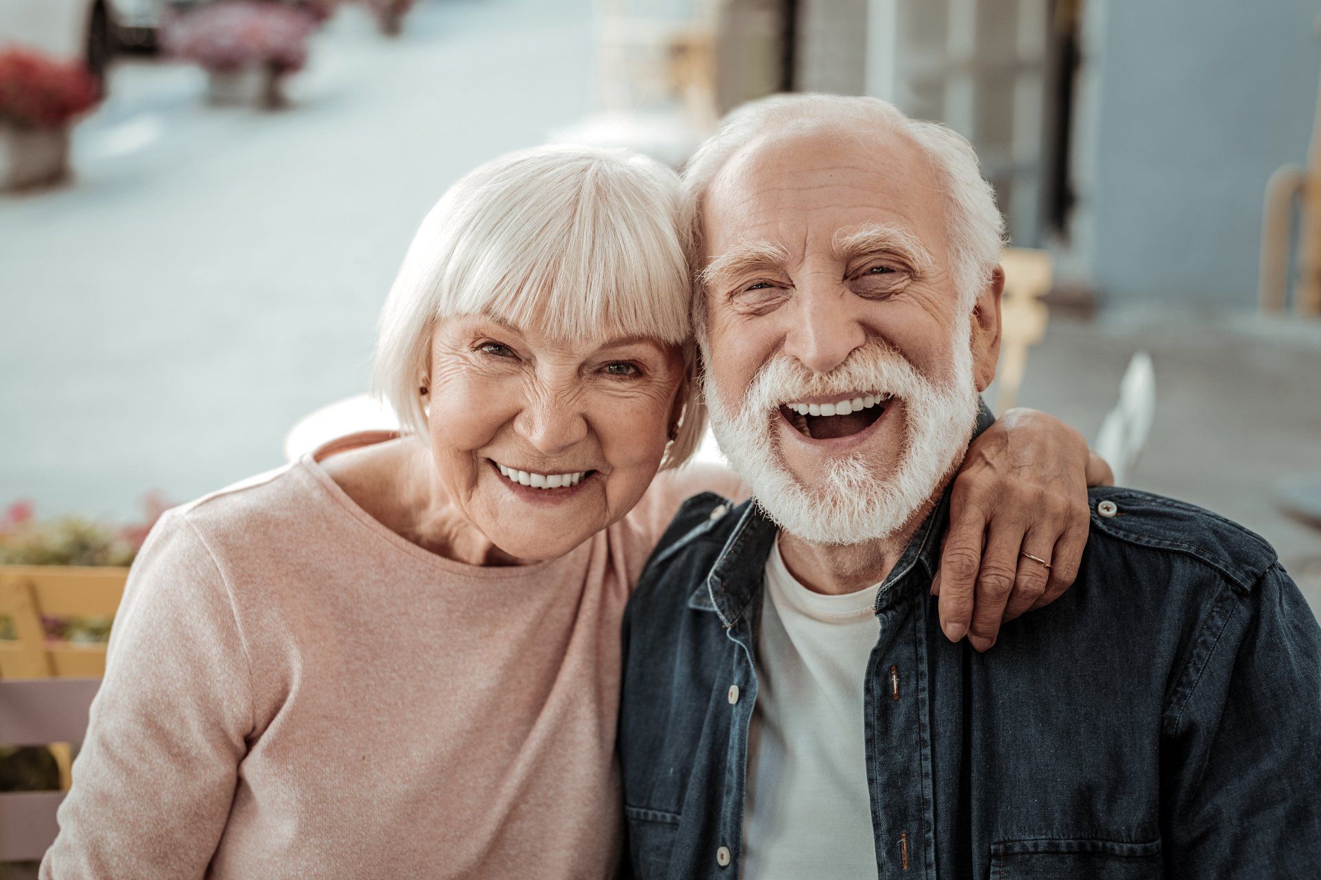 An older man and a woman are posing for a picture and smiling.