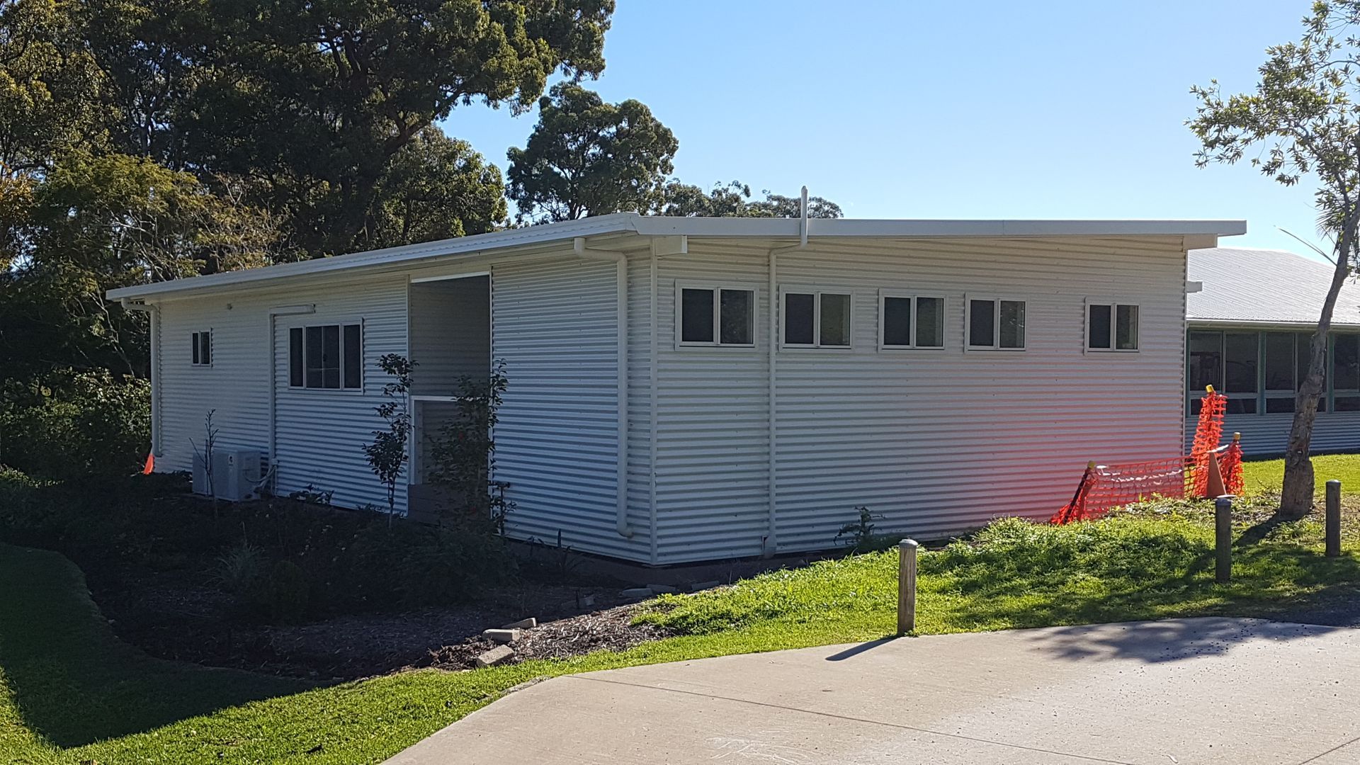 White Building With a Flat Roof, Small Windows, and Corrugated Siding — Acheson Building Certification in Nambucca Heads, NSW