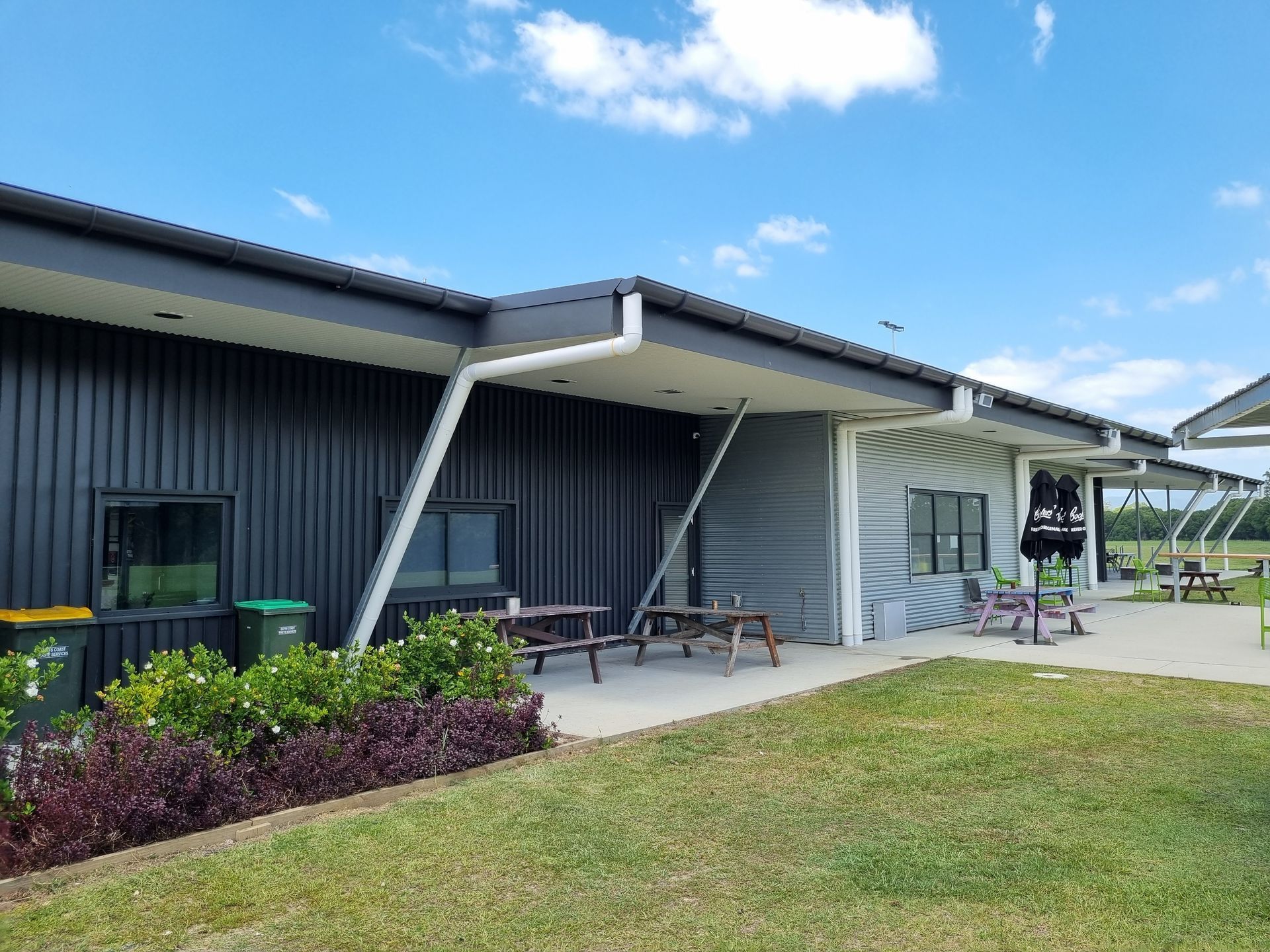 Building With Black and Gray Siding, Outdoor Seating, Green Lawn — Acheson Building Certification in Nambucca Heads, NSW