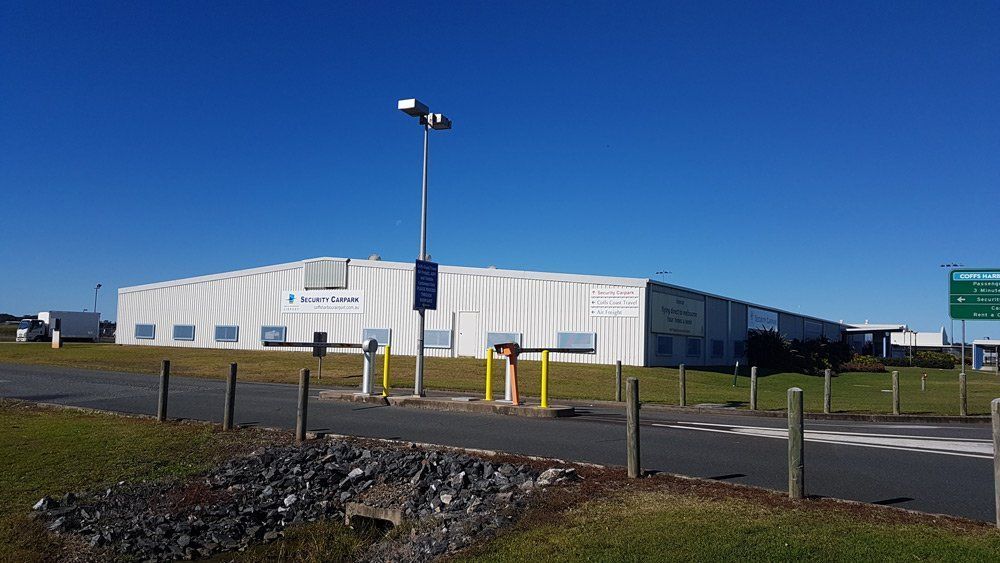 Large White Industrial Building With Blue Trim Under a Clear Sky — Acheson Building Certification in Nambucca Heads, NSW