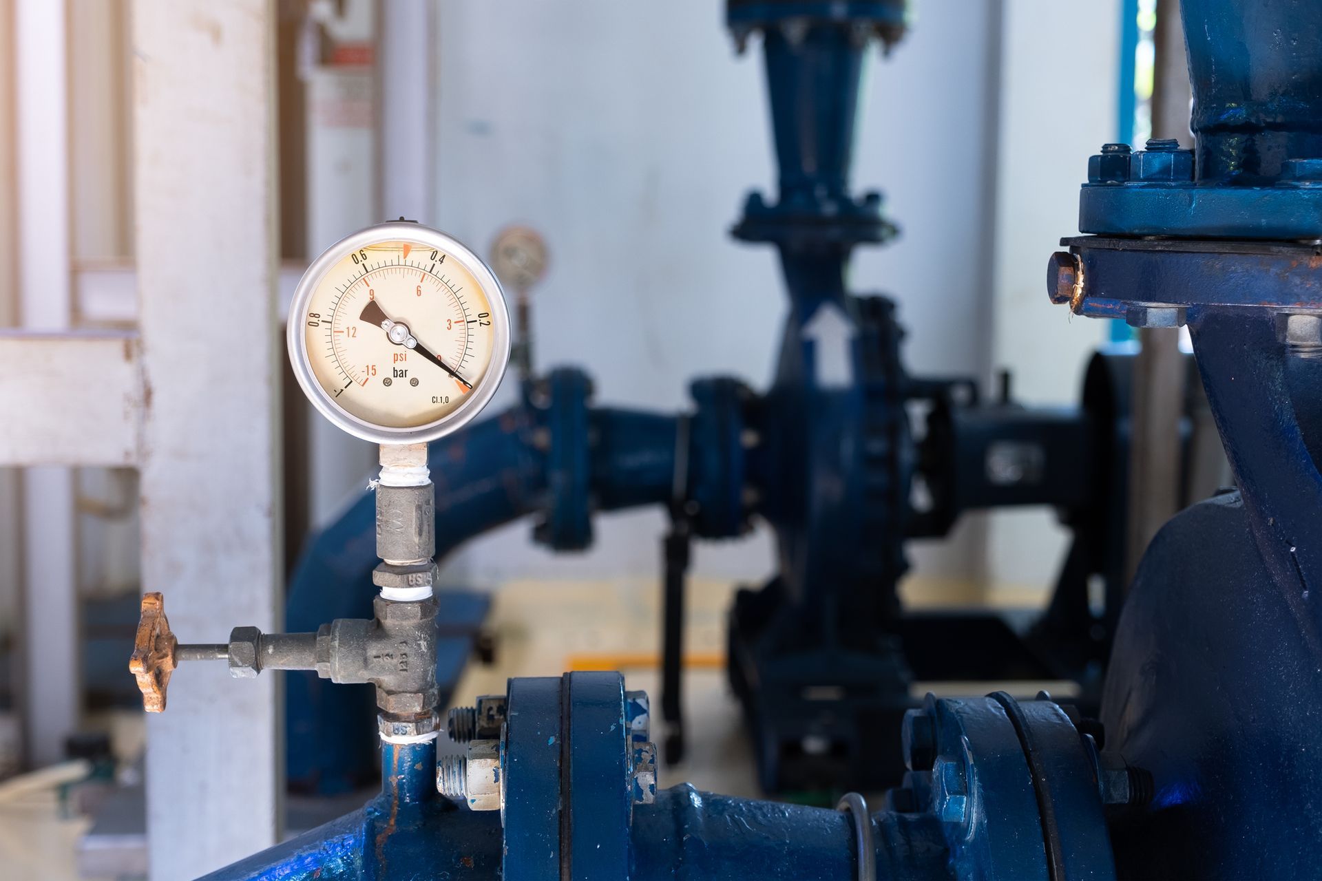 A close up of a pressure gauge on a pipe in a factory.