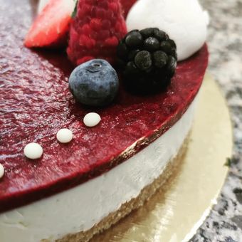 Un primo piano di una torta con frutti di bosco in cima