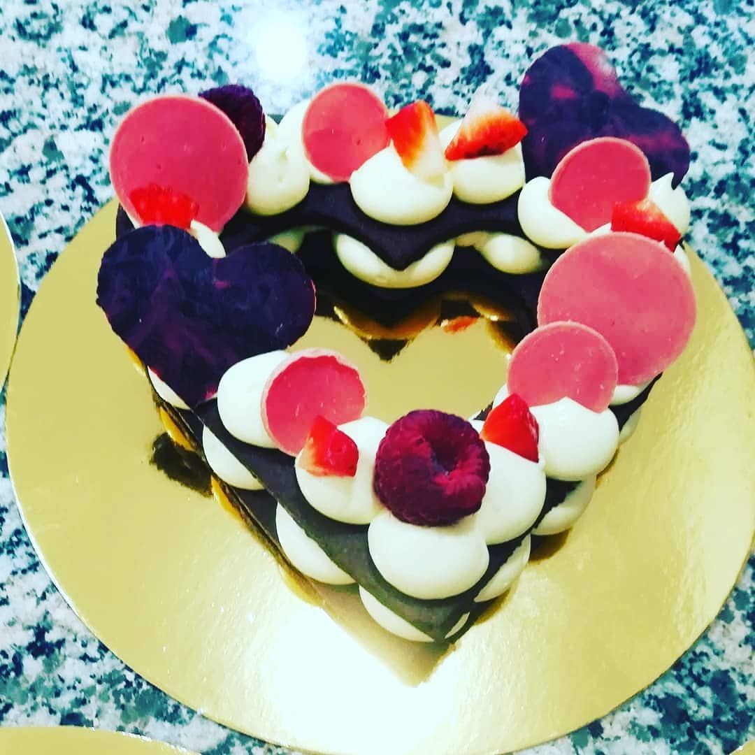 Una torta a forma di cuore con glassa rosa e viola