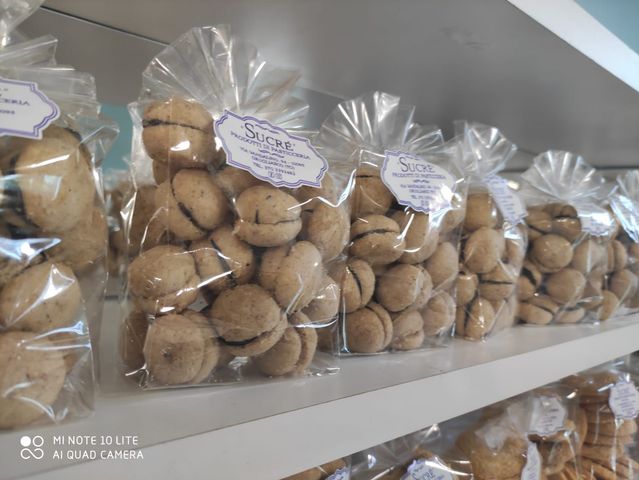 Sullo scaffale di un negozio sono allineati sacchetti di baci di dama.