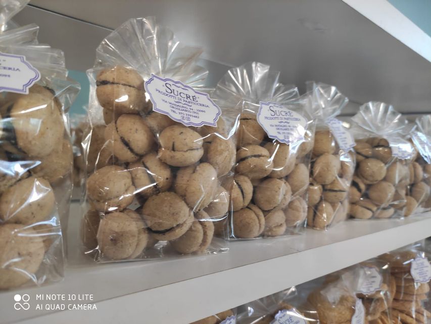 Sullo scaffale di un negozio sono allineati sacchetti di baci di dama.
