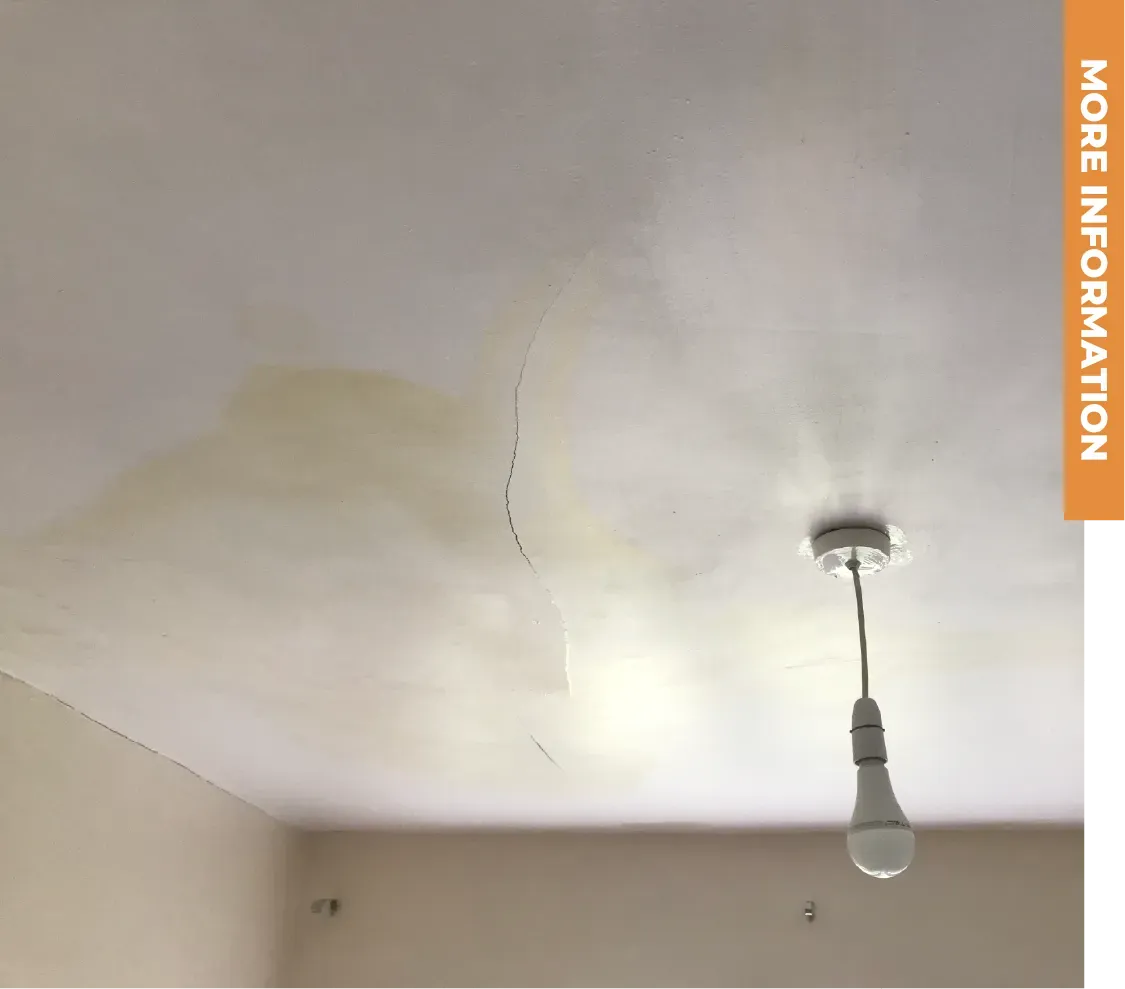 A light bulb is hanging from the ceiling of a room.