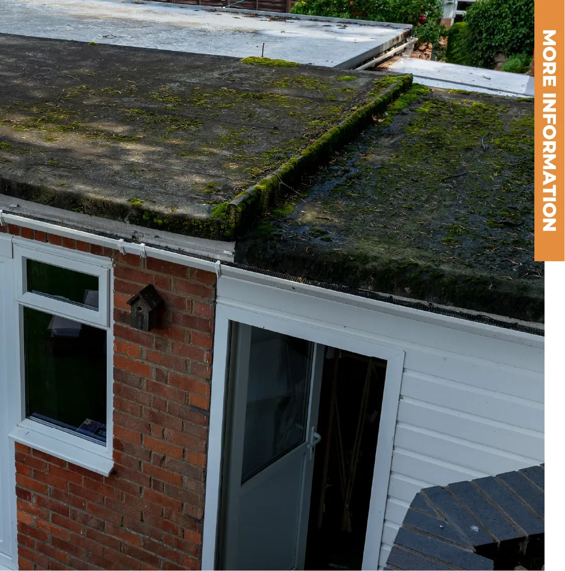 A brick house with a roof that has moss on it
