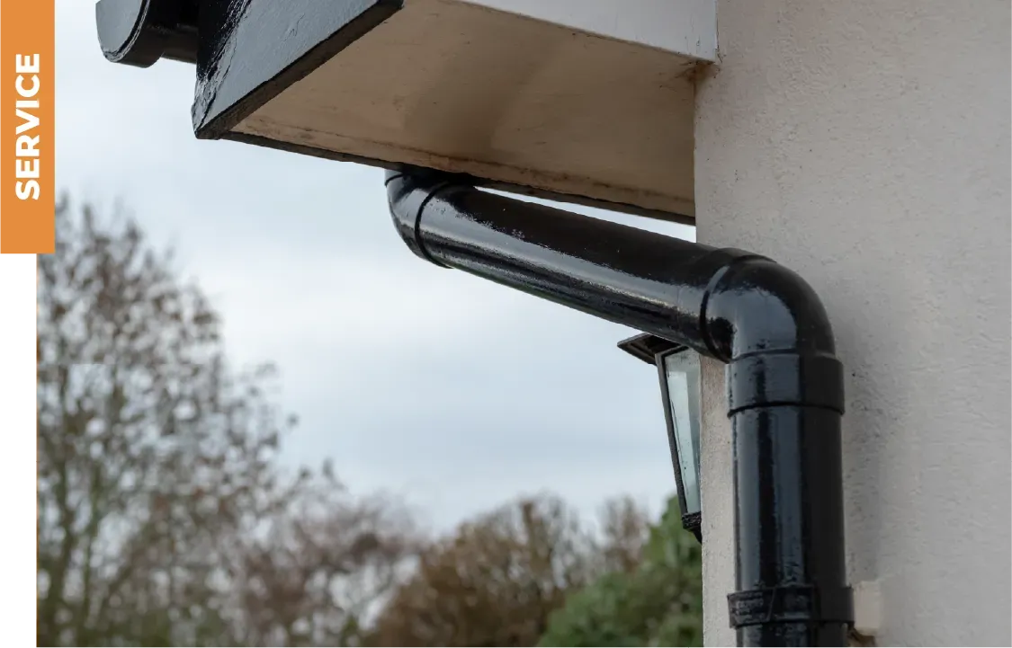 A black gutter is attached to the side of a house.