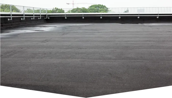 A large empty parking lot with a fence in the background