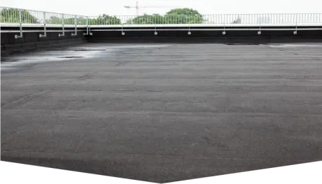 A large empty parking lot with a fence in the background