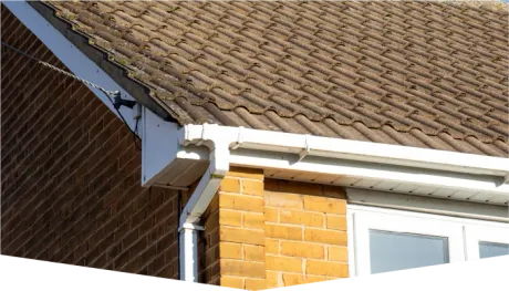 A house with a brown roof and a white gutter