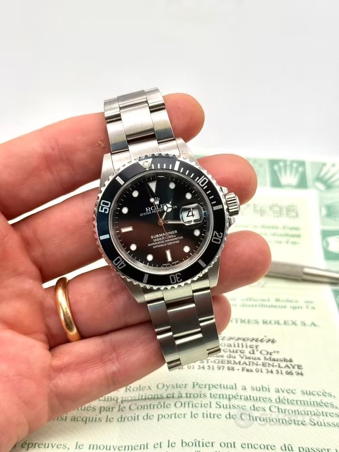 Mano di una persona che tiene in mano un orologio Rolex Submarine