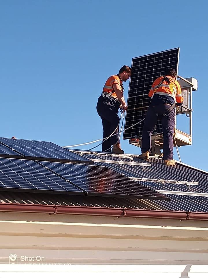Two men are installing solar panels on the roof of a house. — Electrical Worx Warwick P/L In Warwick, QLD