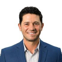 Smiling man in a blue blazer and checkered shirt on a white background