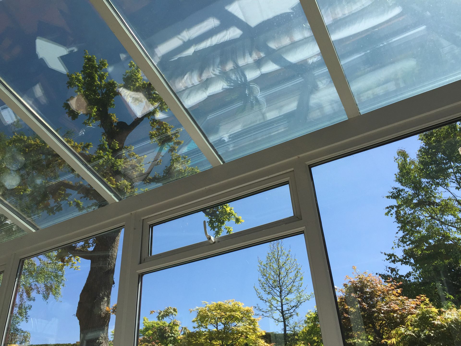Double-glazed doors with a view of trees and blue sky through glass panels.