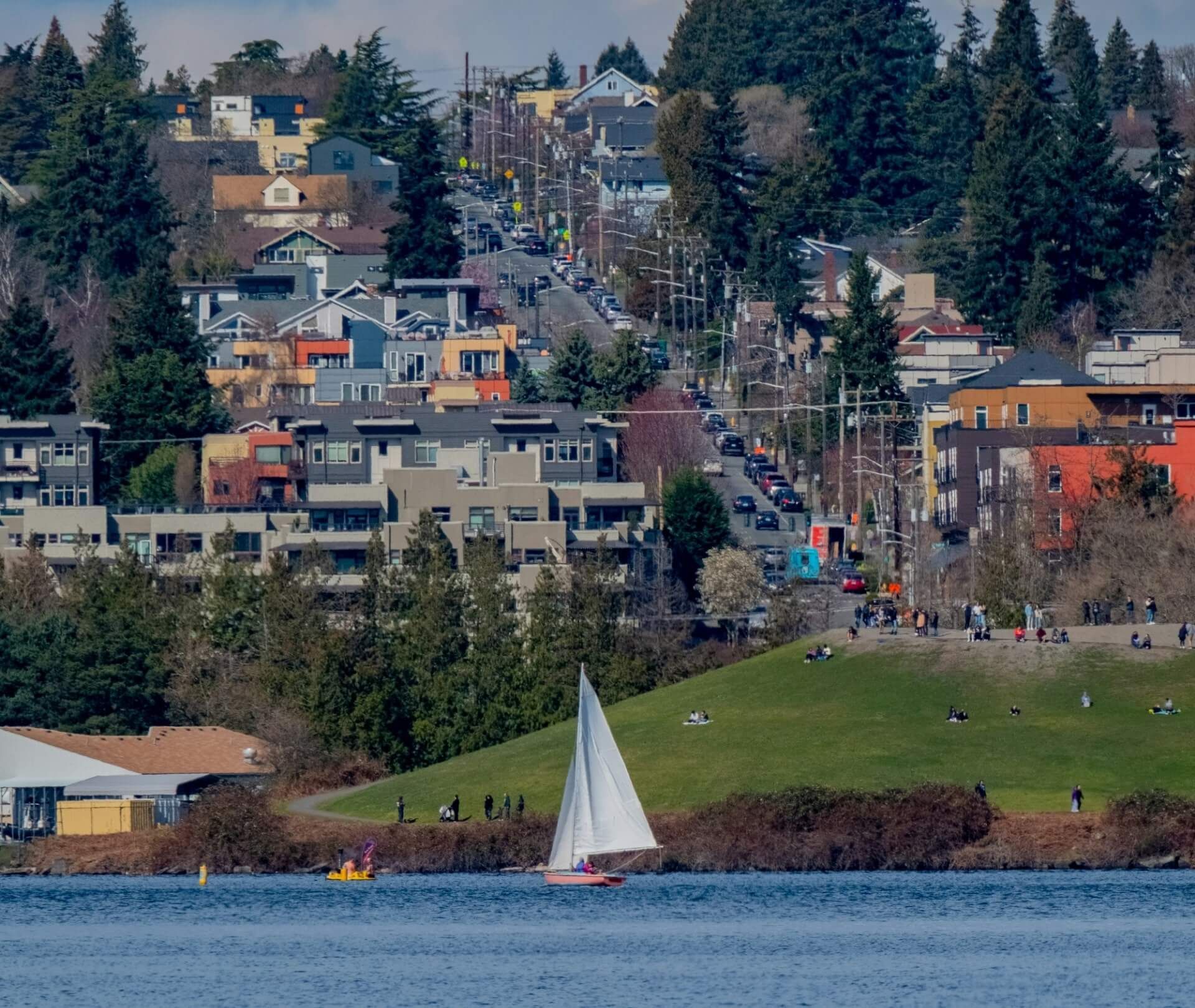 A sailboat is in the water near a city