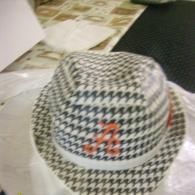 Black-and-white checkered hat with a small red-orange design on top, viewed from above
