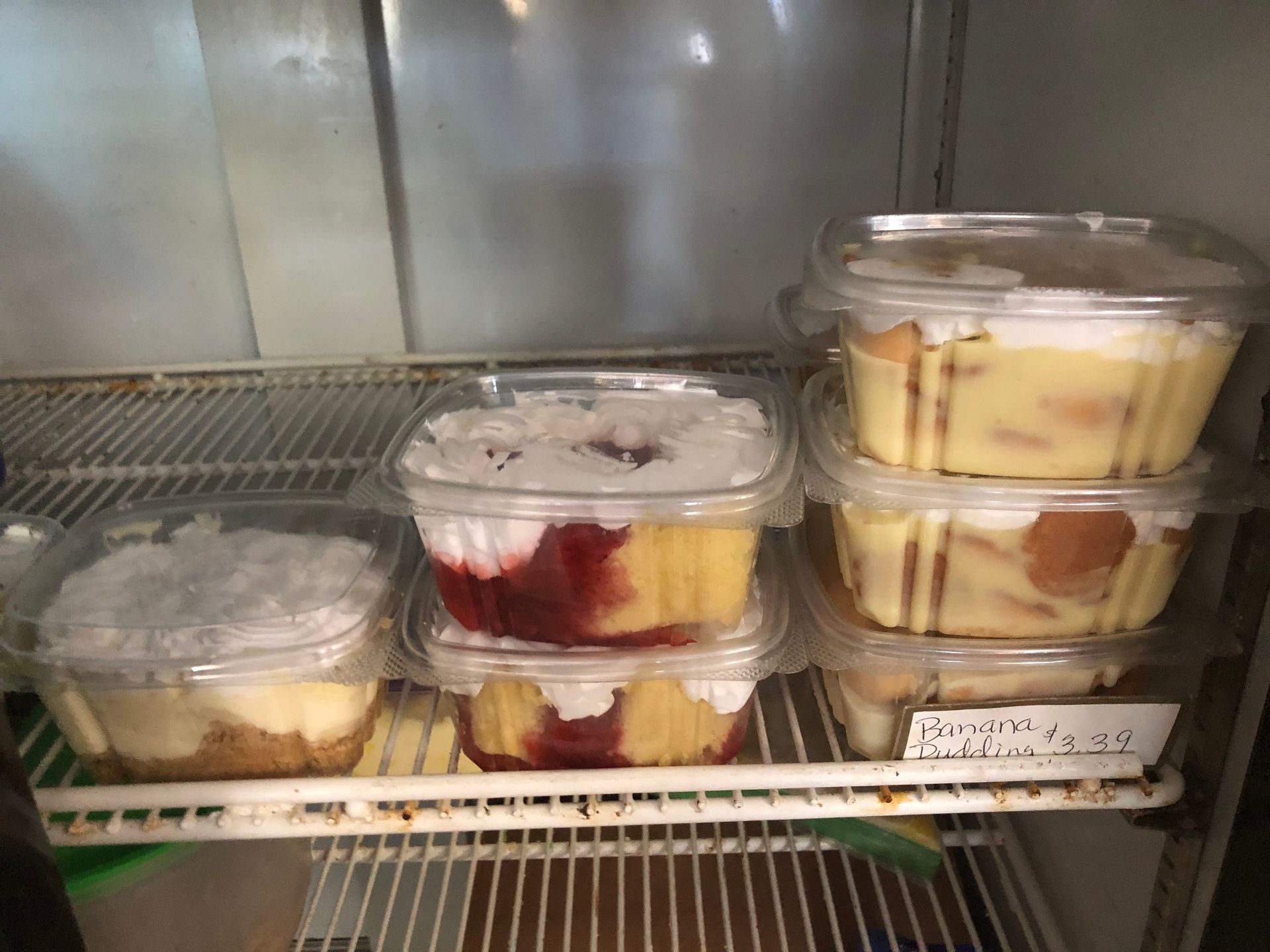 Plastic containers of layered desserts on a refrigerated store shelf