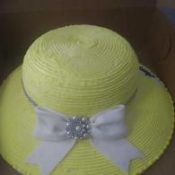 Yellow straw hat with a white bow and jeweled center decoration