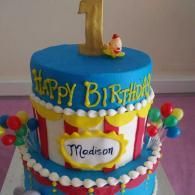 Colorful birthday cake with “Happy Birthday” and “Madison” decorations and a gold number 1 topper