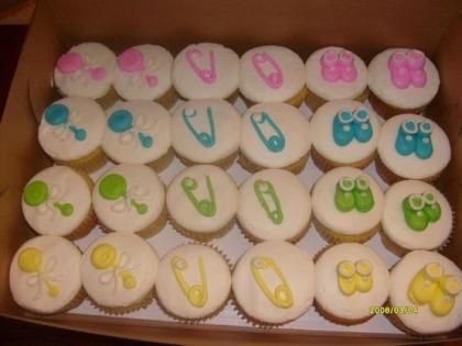 Tray of eggs decorated with colorful icing letters and bow designs in pastel pink, blue, green, and yellow.