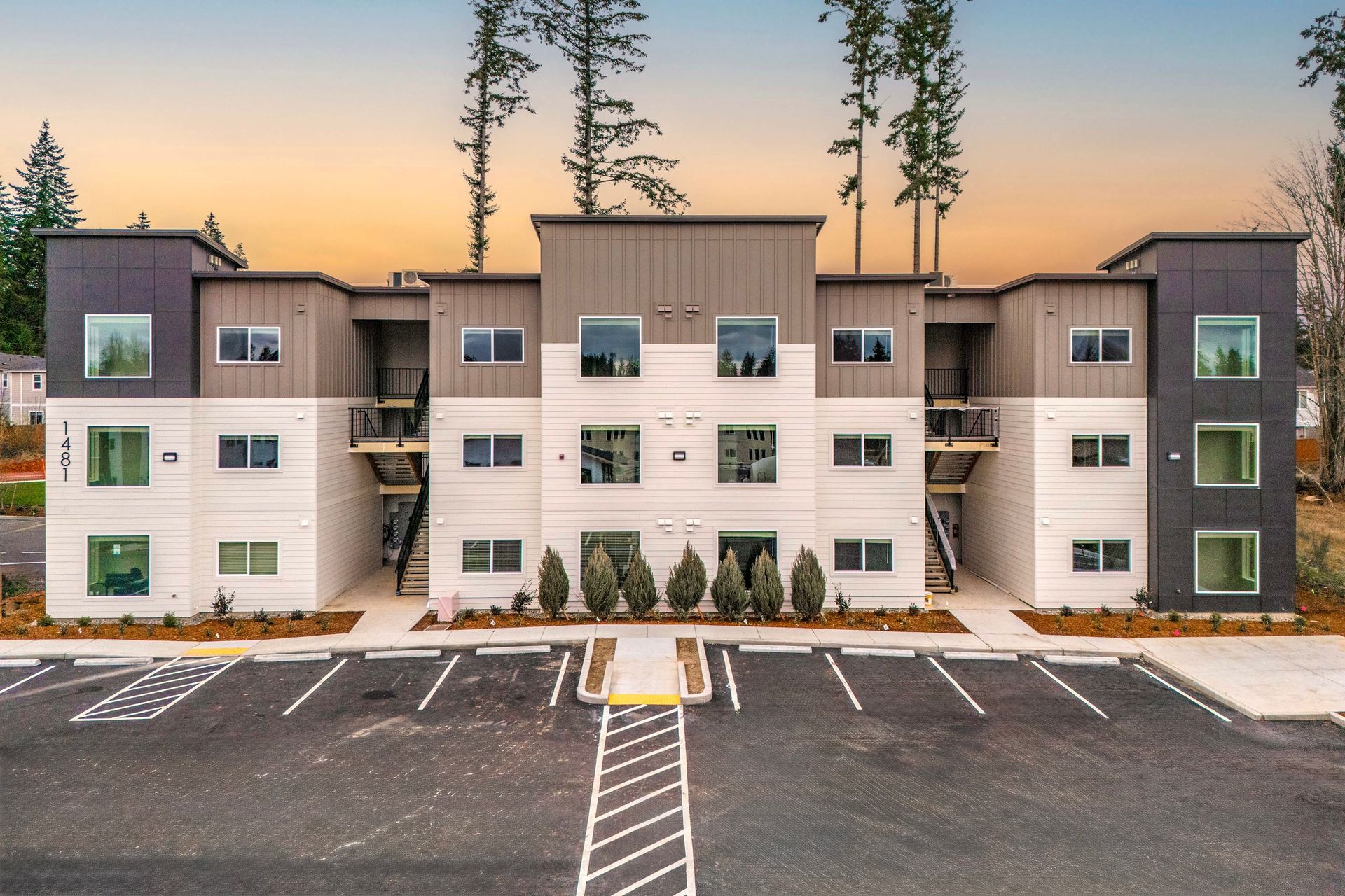 A large apartment building with a parking lot in front of it